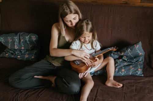 Mother with child playing ukulele