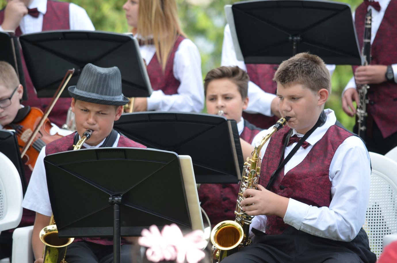 High School students playing in an orchestra and reading music.