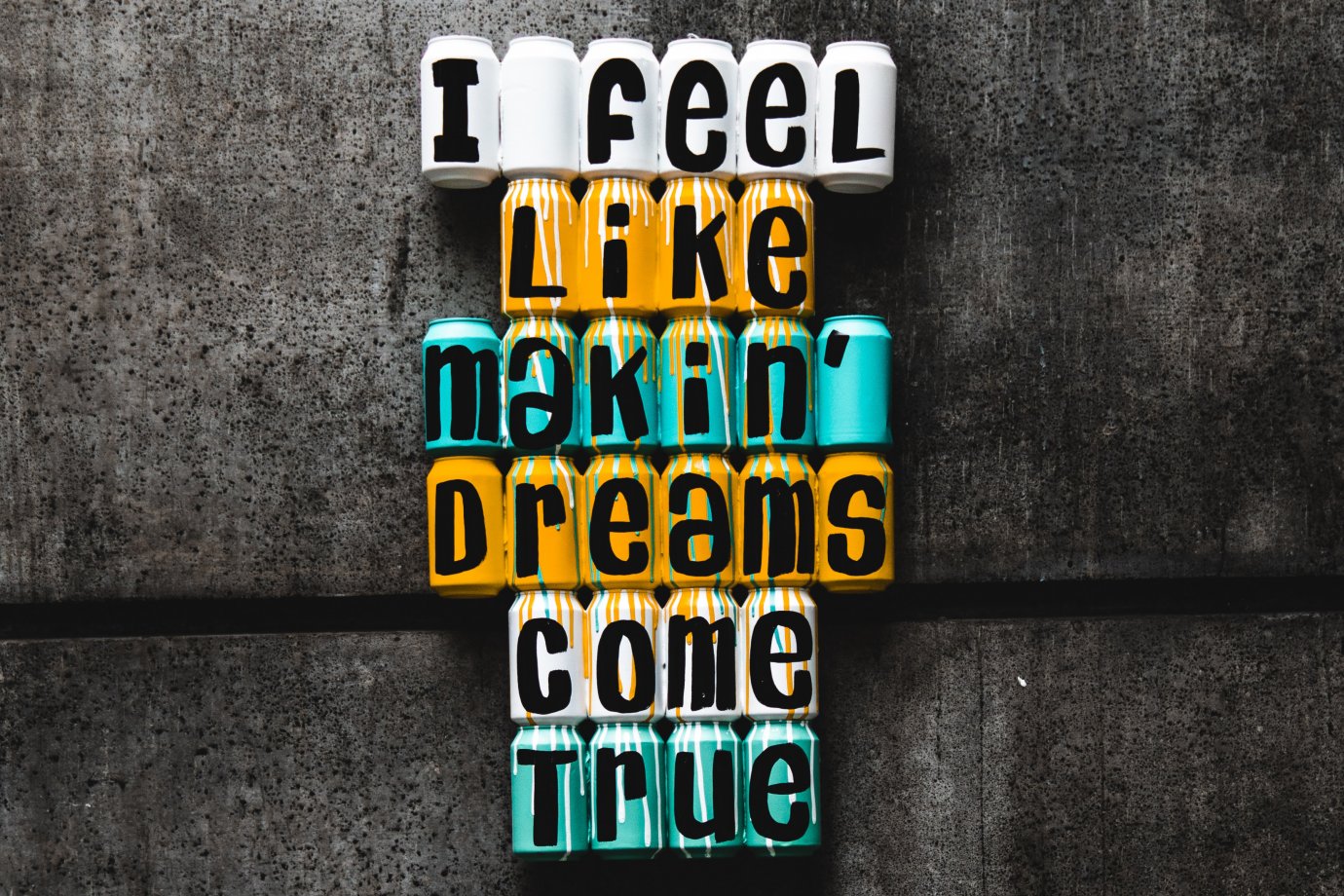 Photo by Peter Fogden on Unsplash Coloured drink cans laid down next to each other with letters on each one. The letters read: I feel like makin' dreams come true.